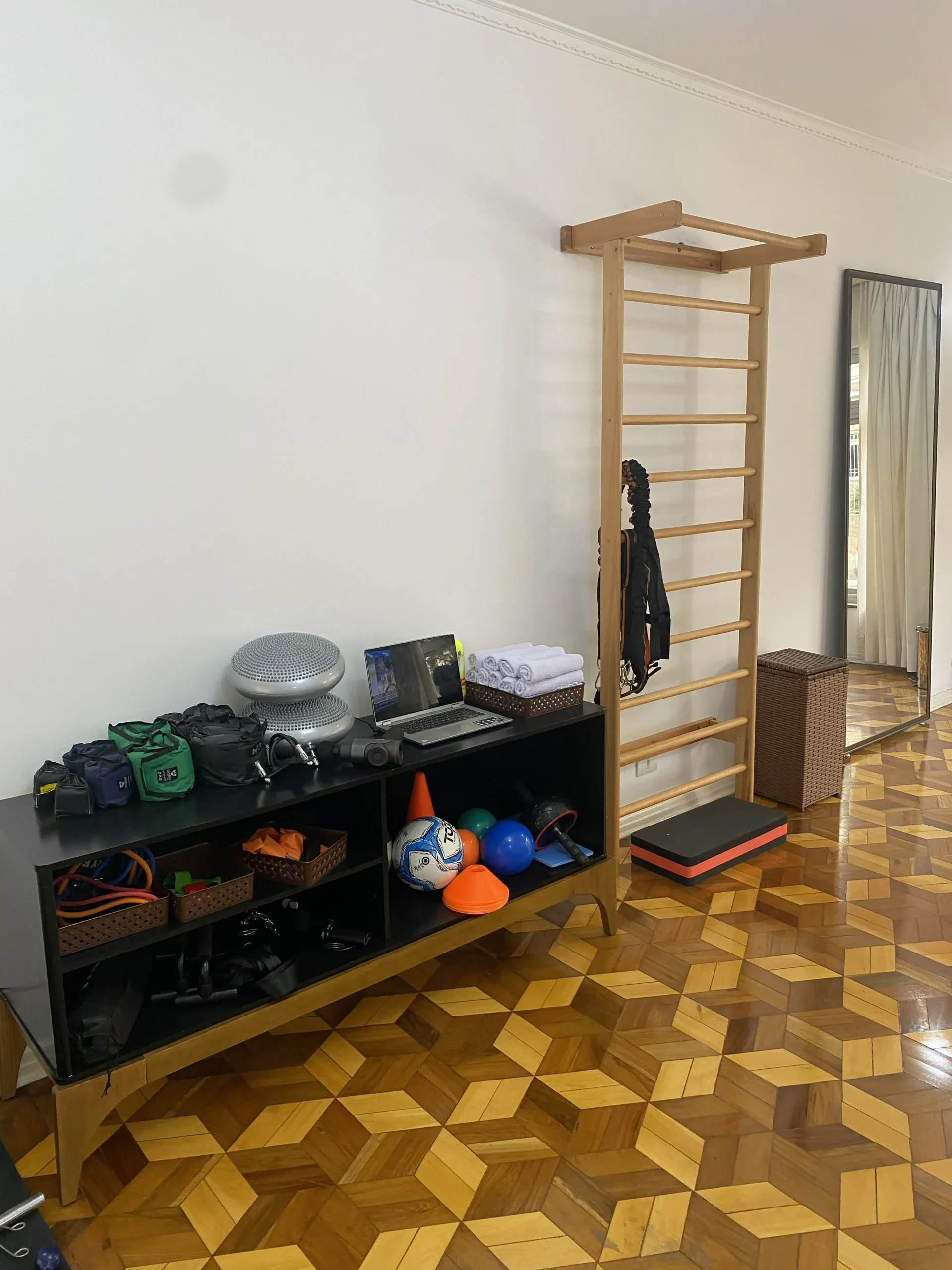 Espaço de exercícios com espaldar de madeira e materiais de treino