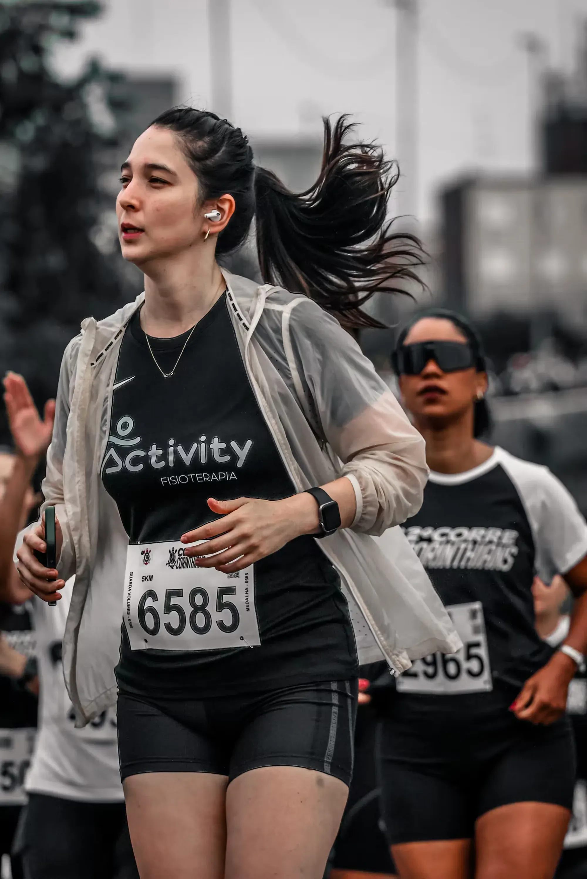 Corredora com a camiseta da Activity Fisioterapia durante uma prova de rua