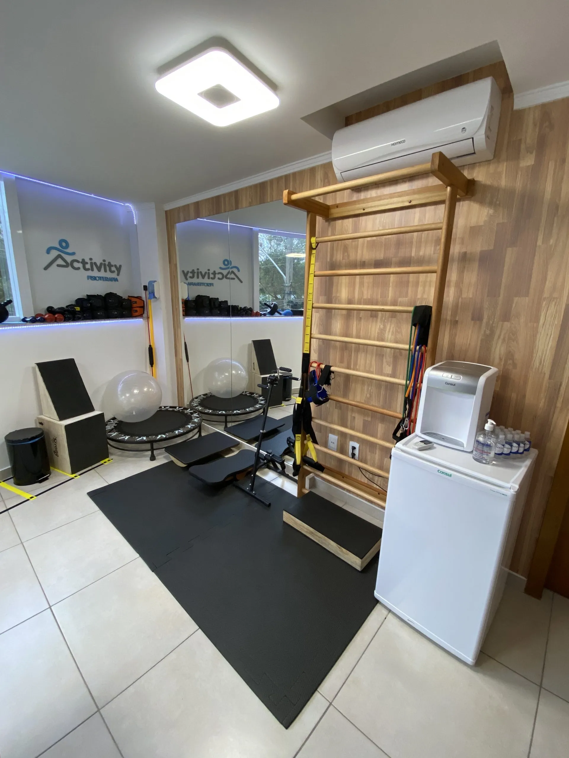 Sala de exercícios com espaldar, espelho e aparelhos de treino
