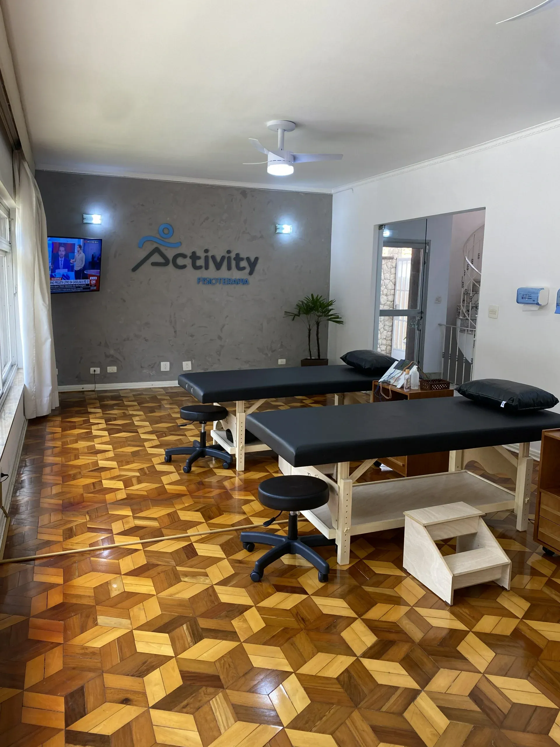 Sala de atendimento com macas e o logo da Activity na parede